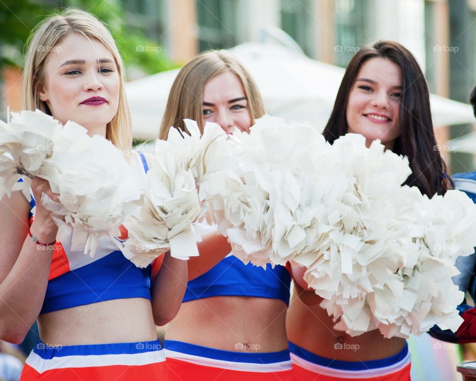 Close-up of cheerleaders holding pom-pom in hand