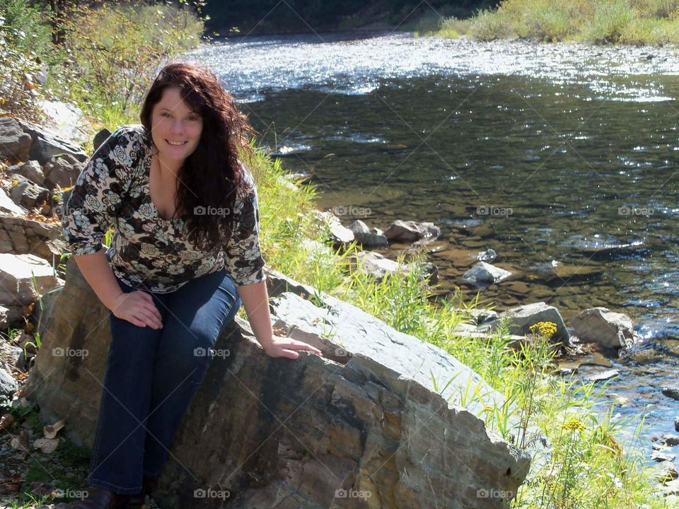 Pretty woman posing beside the river. model, long hair, brunette.