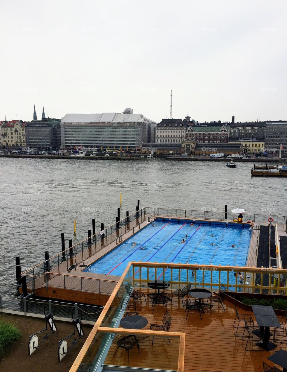 Bright blue water open swimming pool in the city harbour area 