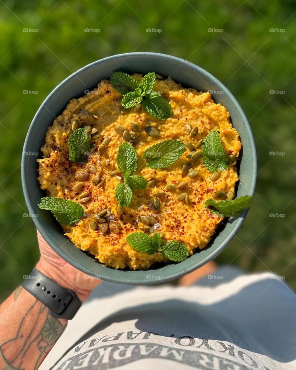 Chef holds dish out to photograph it, cooking authentic food, cooking fresh and healthy food 