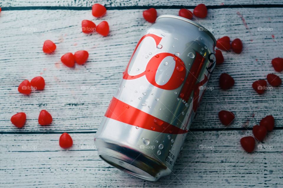 A can of Diet Coke with candy heart on a white rustic background