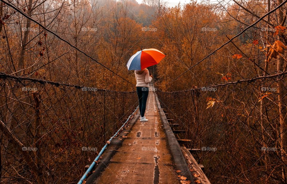 On a bridge with umbrella