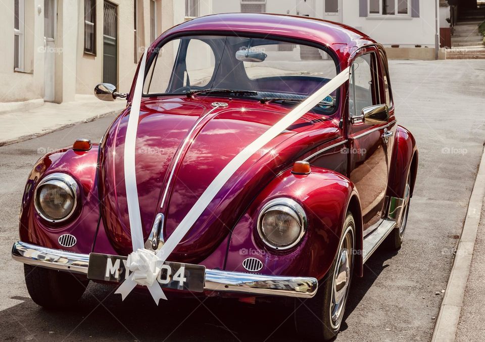 Vintage, red Beetle car, with ribbons for a wedding