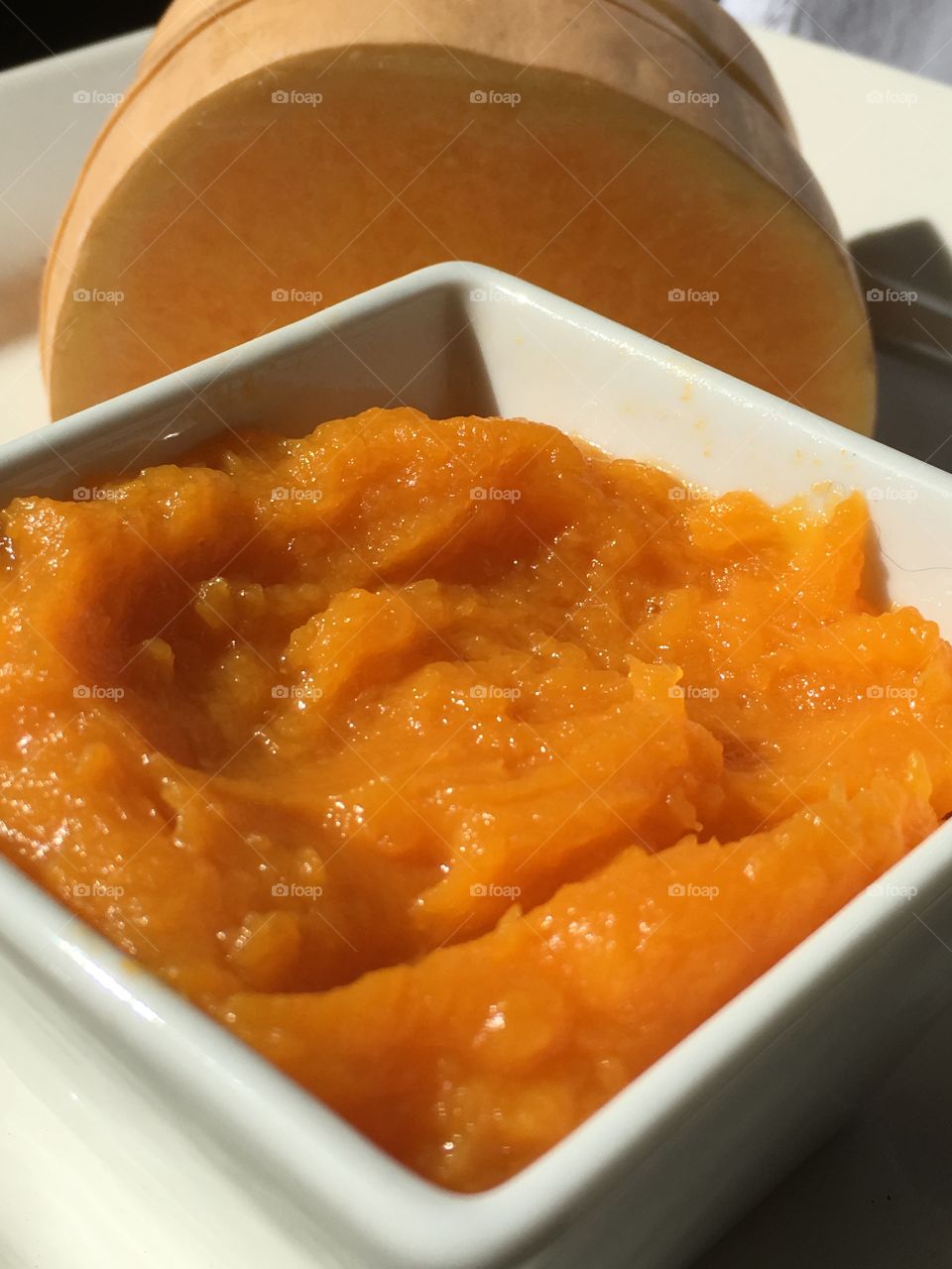 White bowl of mashed orange squash closeup cuisine