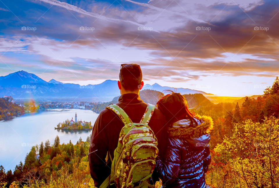 Happy couple enjoying sunrise . Happy couple enjoying sunrise over lake Bled in autumn, sLOVEnia, Europe 