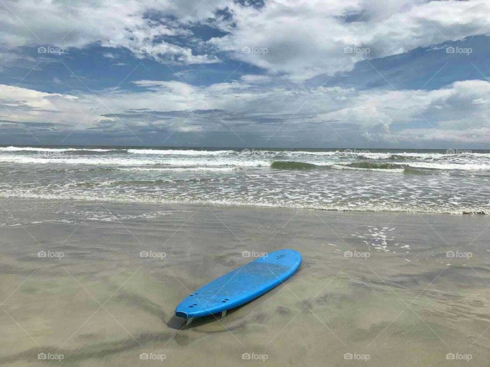 Lost surfboard on New Smyrna Beach. Pretty cool shot here of a surfboard without a surfer washed up on shore on this Central Florida beach known for surfing and shark attacks. I just hope whoever owned this wasn't shark bait!!
