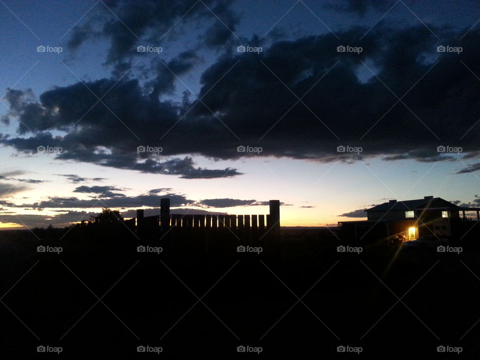 sunset over house in field