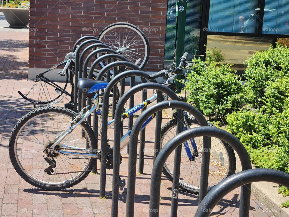 bike rack with parked bicycles in front of urban building