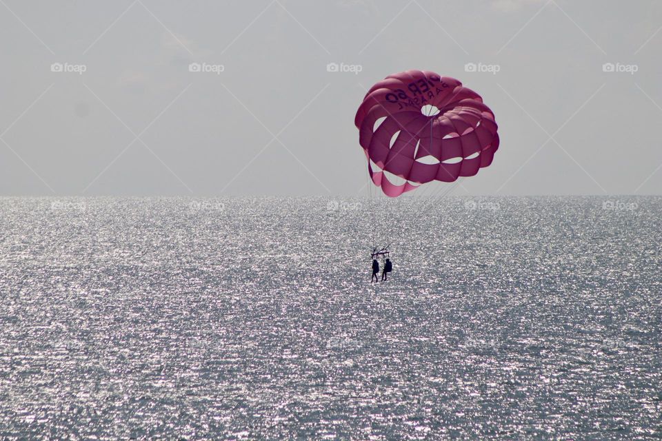Parasailing summertime dream over silvery seas of Gulf of Mexico