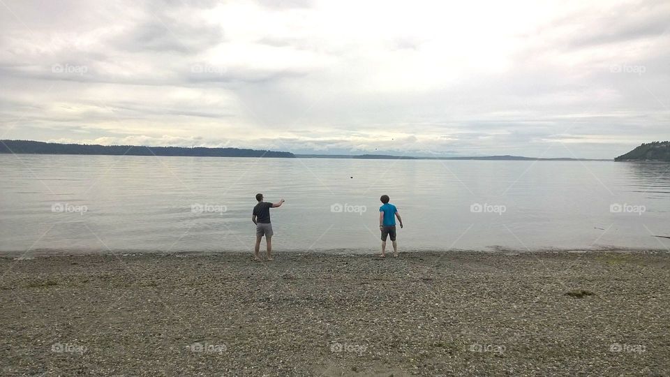 Boys skipping rocks