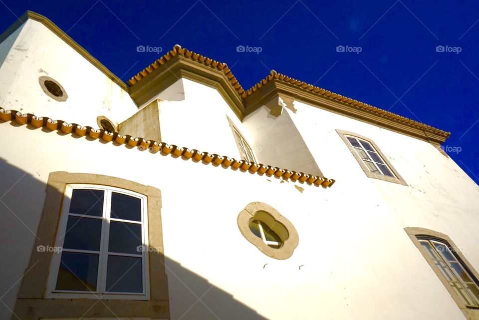 Portuguese Villas. Beautiful whitewashed villas under stunning blue skies along the streets of the old town in Faro, Portugal. 