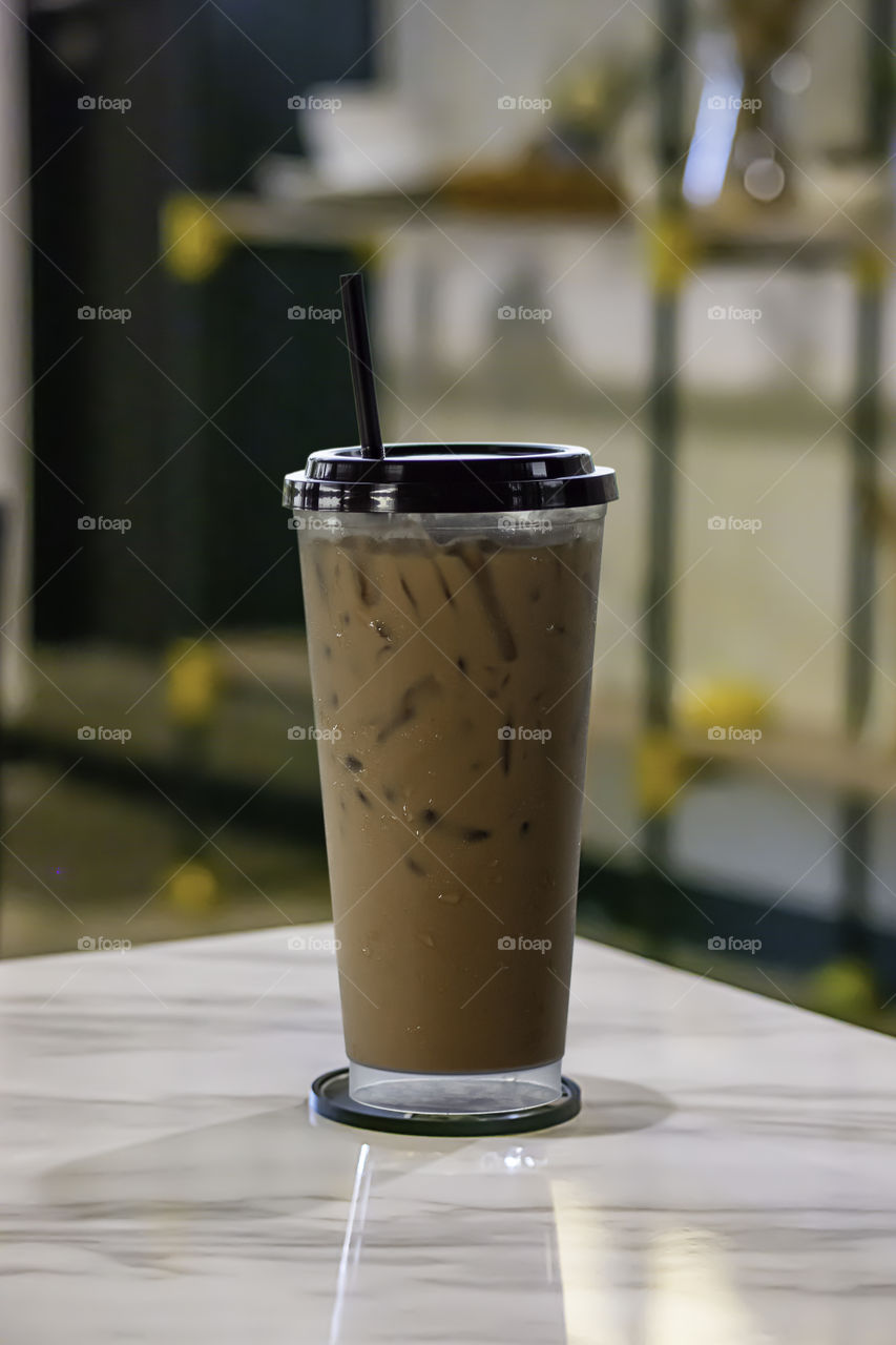 Iced coffee put whipped cream in a glass on the table.