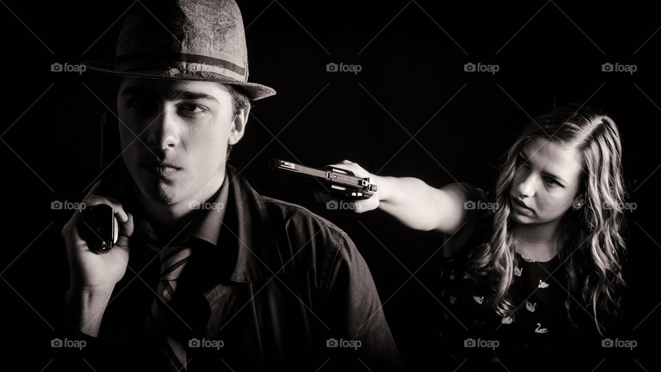 Young man and woman holding gun in hand