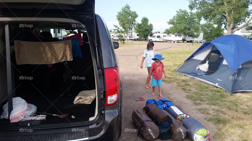 packing/unpacking open trunk of van at campsite with children