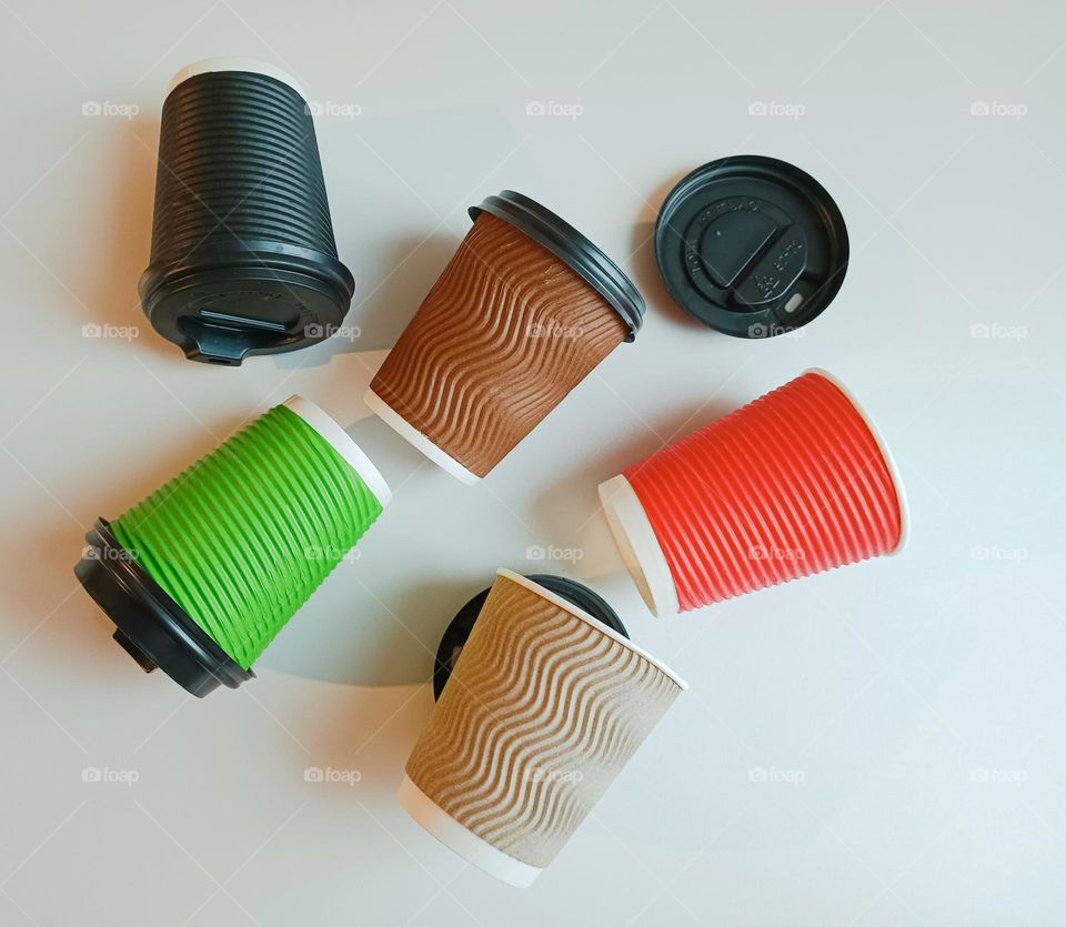 Multicolored paper cups for coffee. Eco-friendly disposable paper packaging. The concept of recycling waste, paper and cardboard.