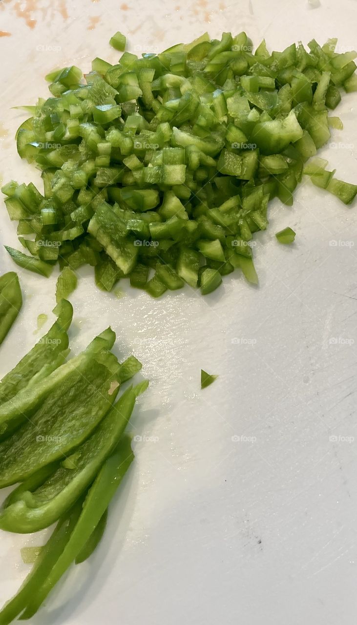 Chopped green bell peppers on white cutting board