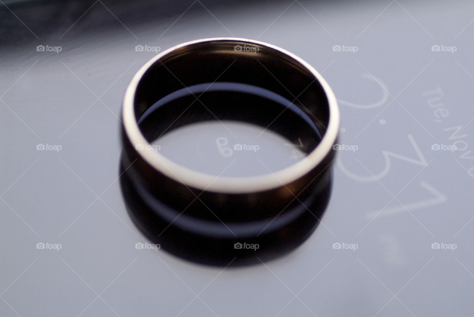 A wedding band sits atop a cell phone