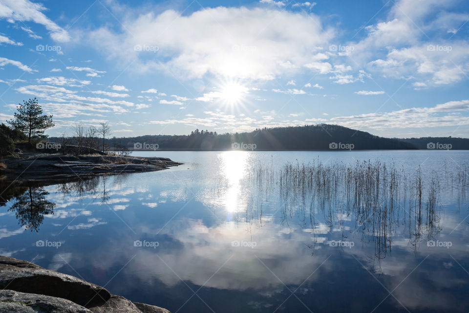 Sun and sky reflection in mirror lake , Swedish landscape in winter 