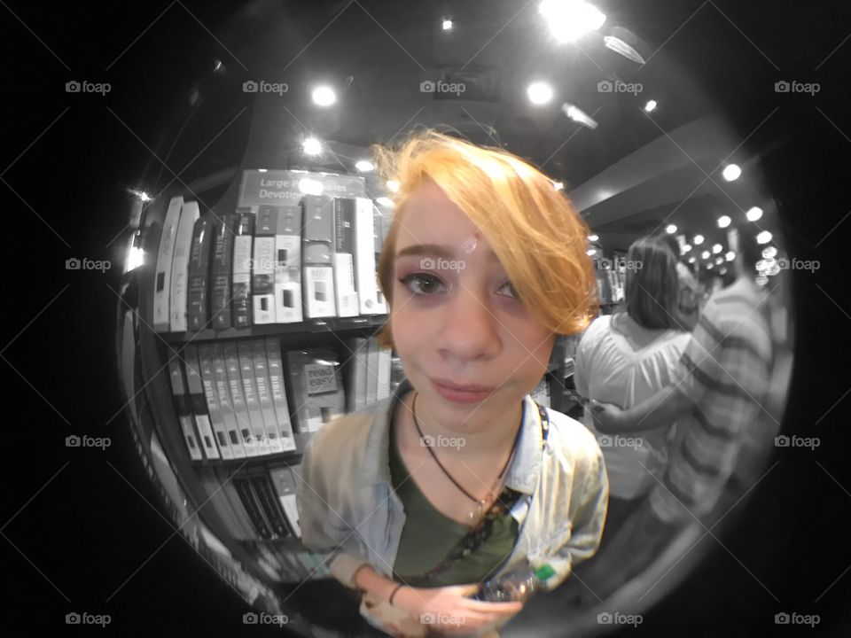 Fish eye lens view of a young woman in library
