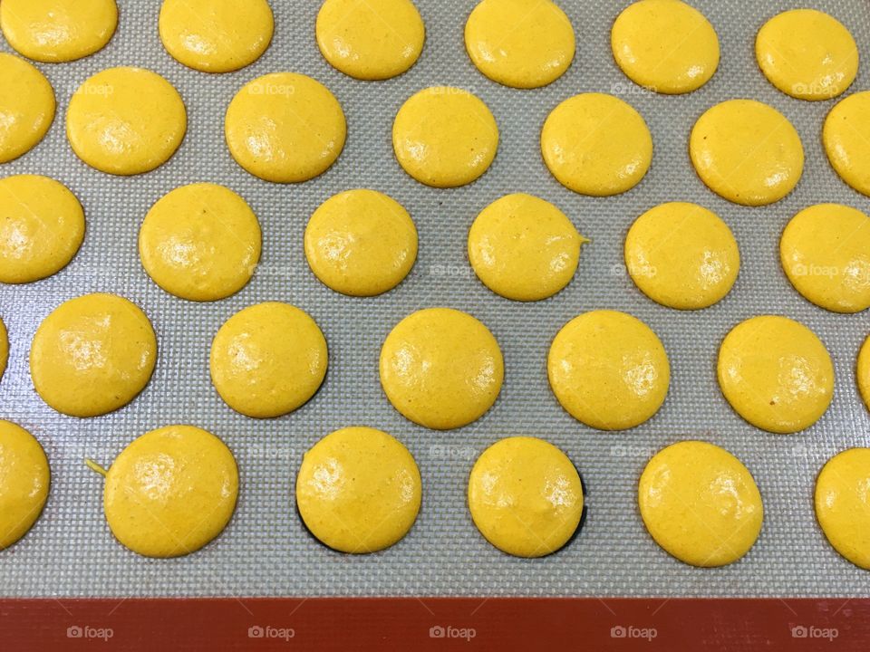 Yellow macarons on a baking tray