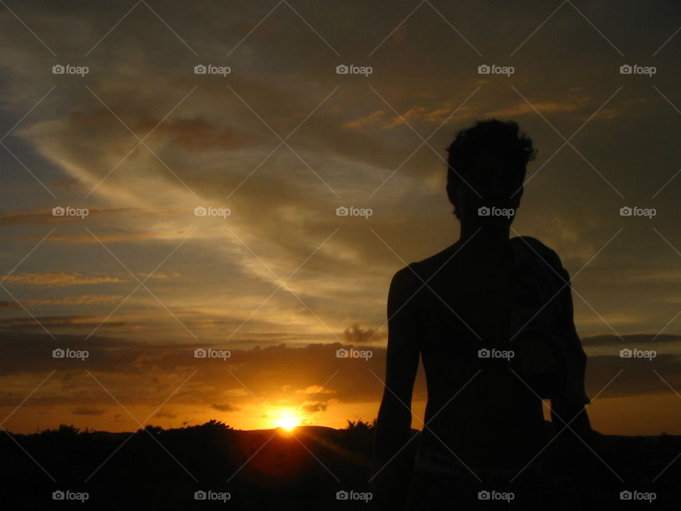Silhouette of a young man in the sunset