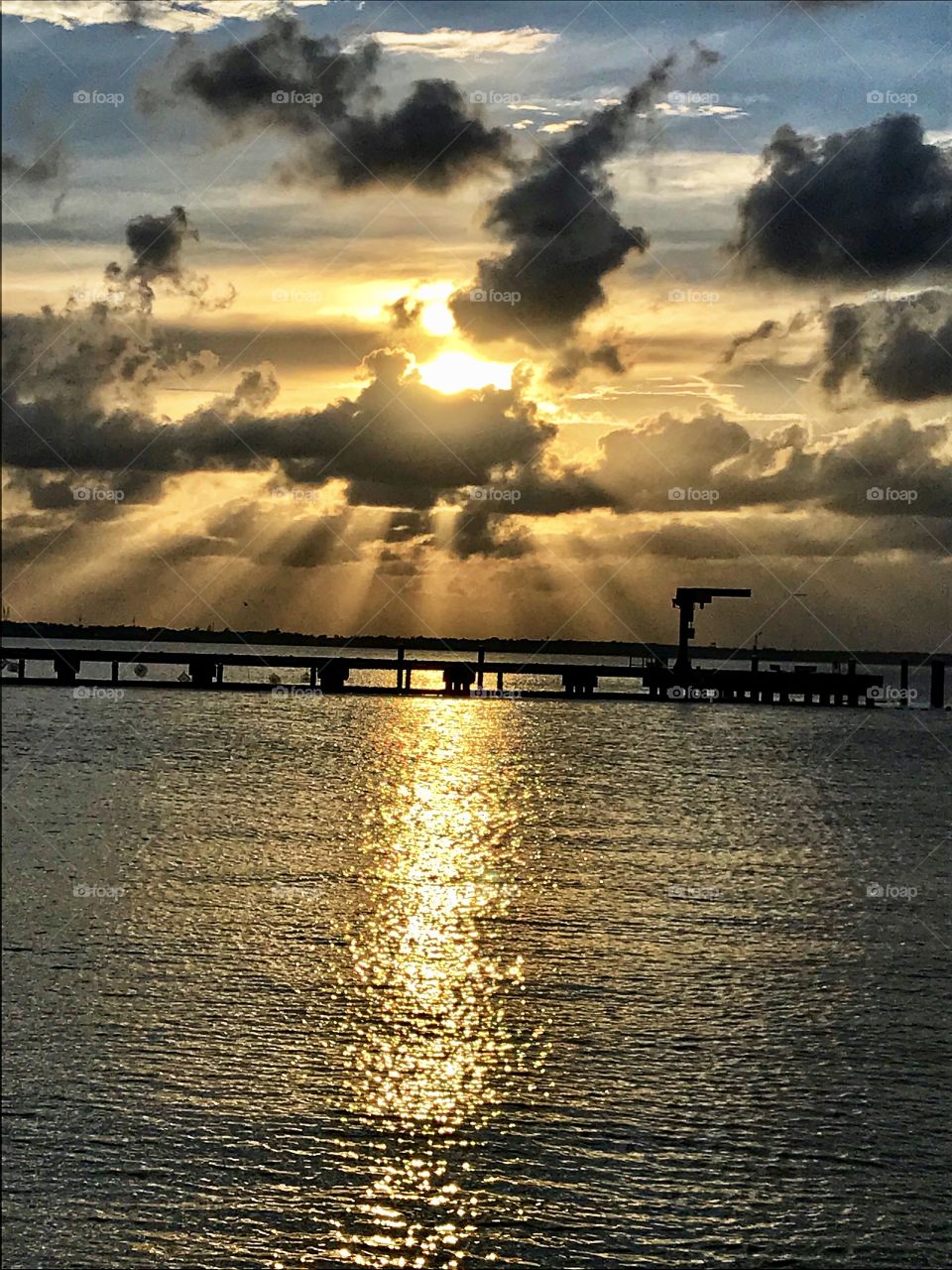 Sunset over the harbor with sun rays and reflections 