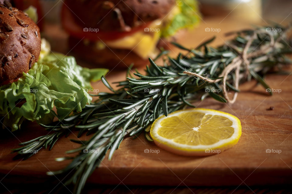 Lemon with rosemary on wooden board