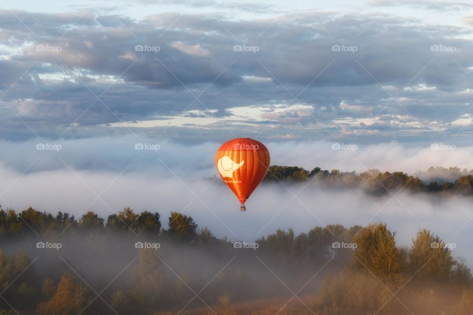 Hot air balloon ride in early autumn over foggy Trakai in Lithuania.