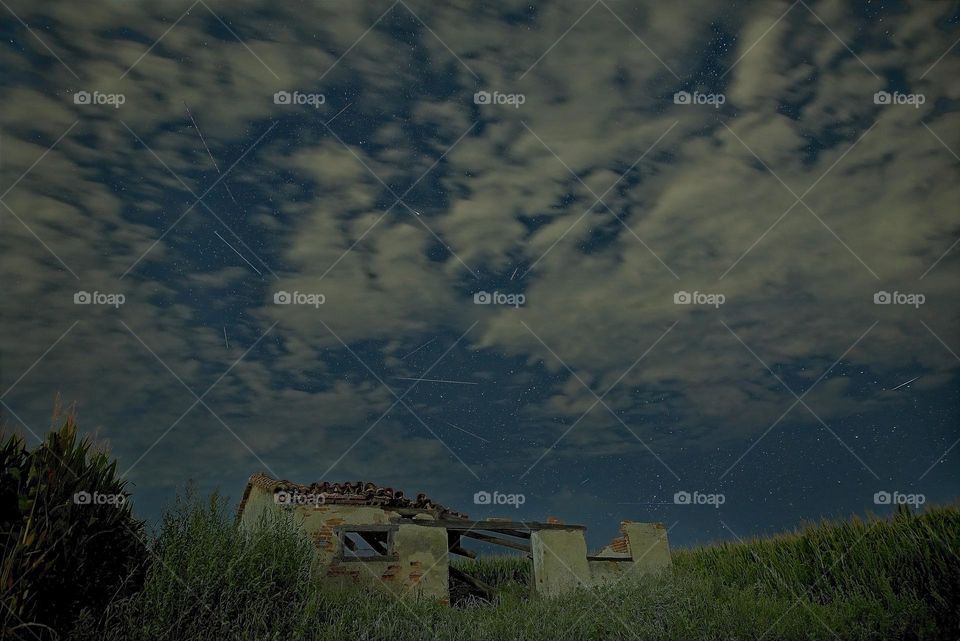 Night of shooting stars on a ruined house