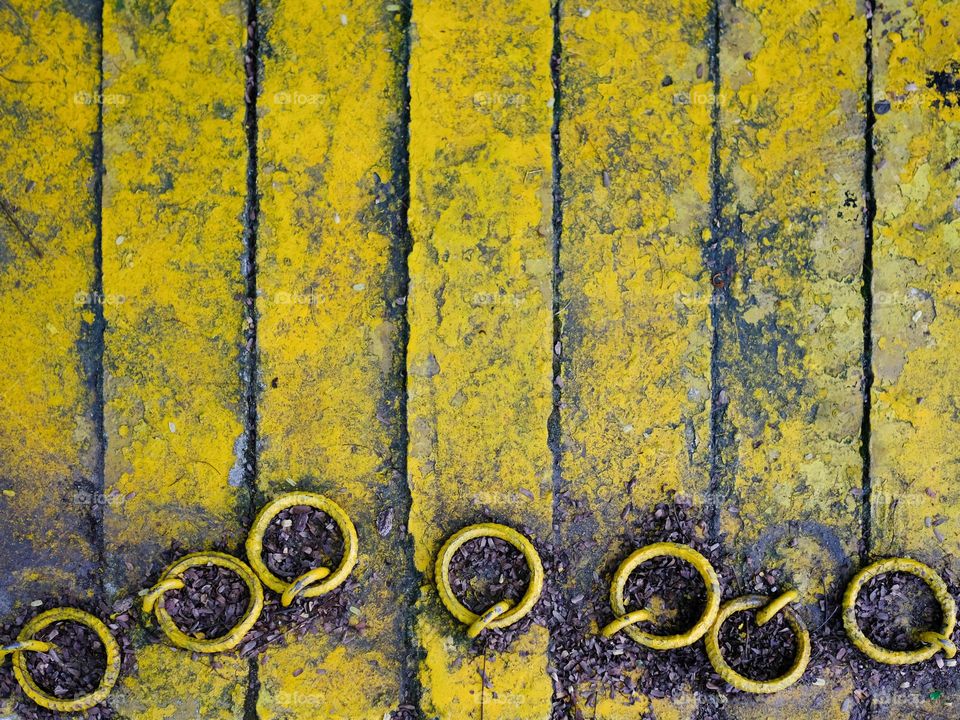 Close-up view of yellow concrete covers with metal rings