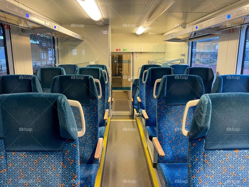 The empty wagon of the České dráhy company with blue seats.