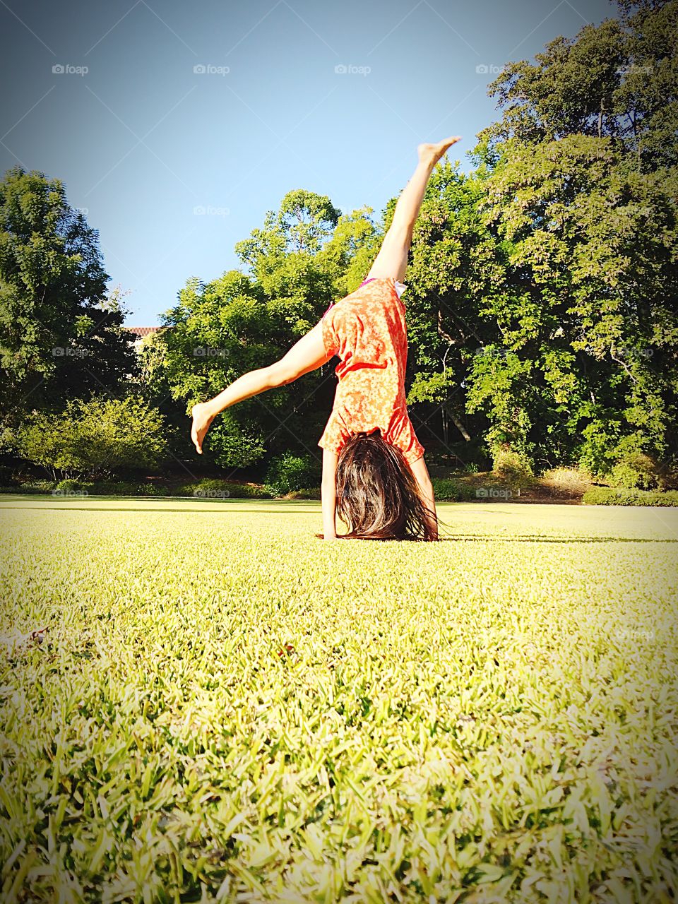 A girl doing cartwheels at the field