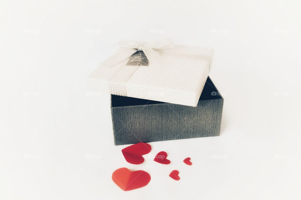 Valentine's day : closeup on a small opened gift box with heart shaped on a white background