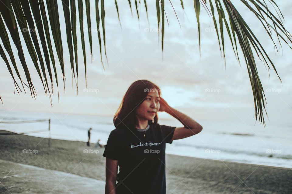 a photo of an island girl at a sunset backdrop