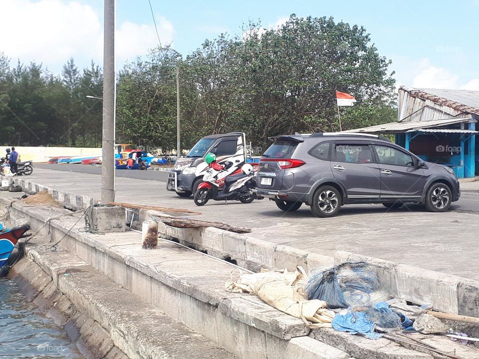 Cilacap, 2023, Indonesia : the fishing port is busy with people in the morning at sunny day