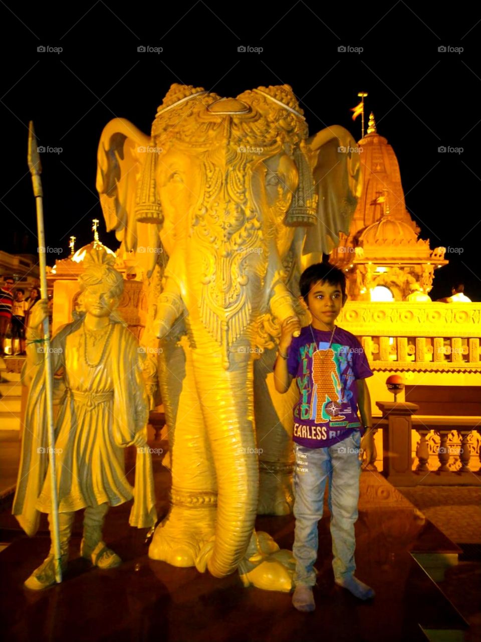 Nice little boy standing near so cute statue of elephant so pretty boy looks so nice