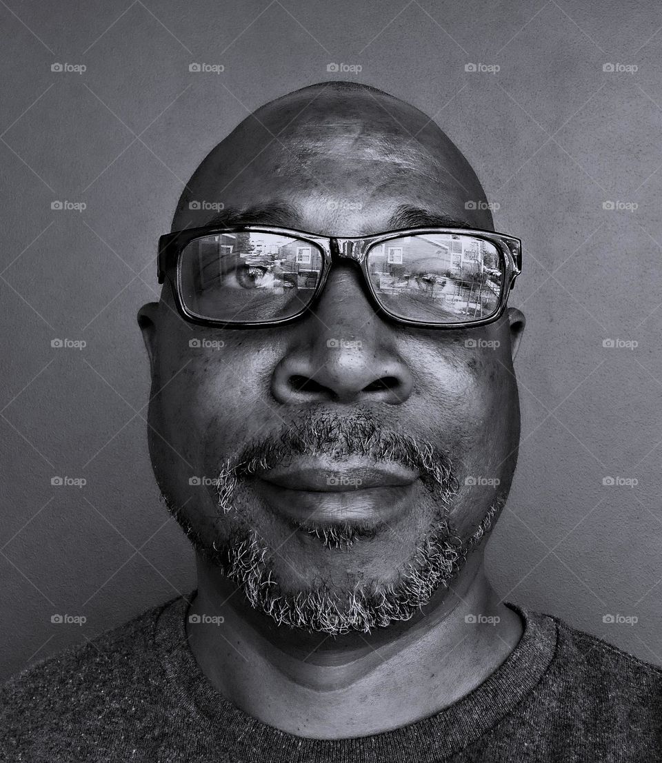black and white portrait of a man with a goatee wearing glasses