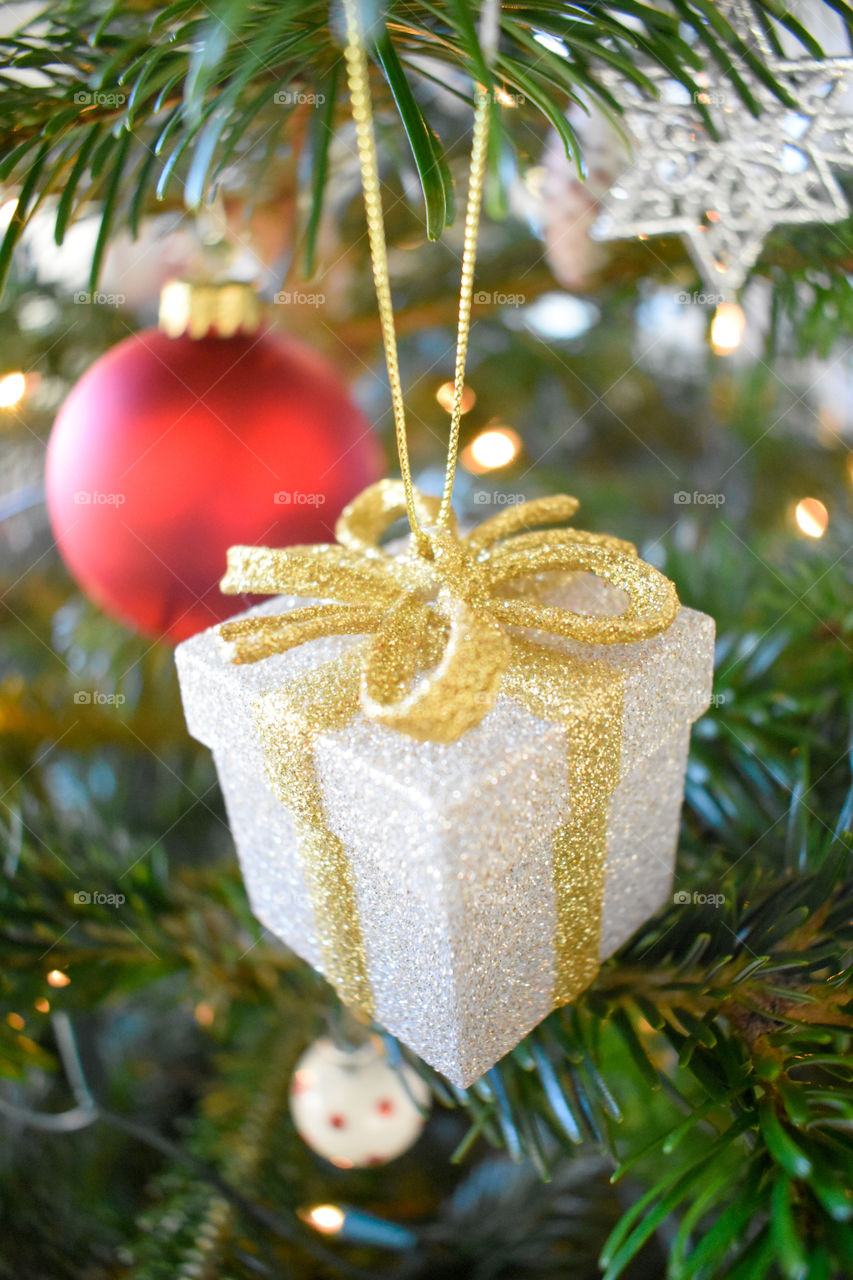 a present and a tree ball in the Christmas tree