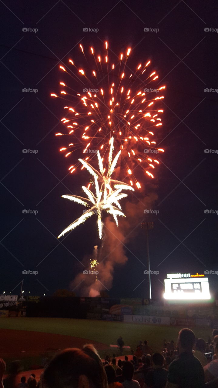 Fireworks at baseball game. Red and white fireworks light up the night sky after a Frederick Keys baseball game in historic Frederick Maryland