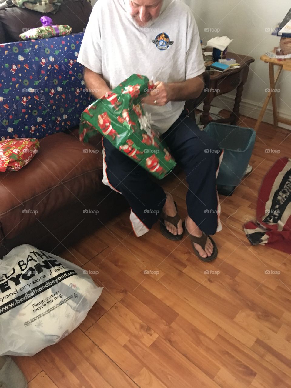 Husband opening up his presents what could it be maybe a shirt 