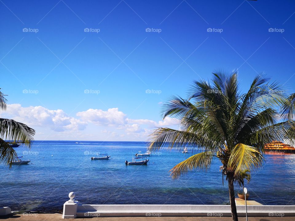 vista desde el malecón de la isla de Cozumel, cerca del muelle de los ferrys y embarcaciones pequeñas, un día soleado y despejado, perfecto para ir a la playa o pasear por aquí.