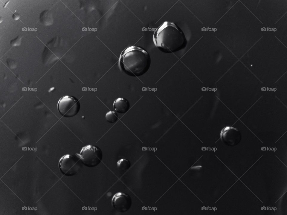 Small air bubbles in a glass close-up in black and white.