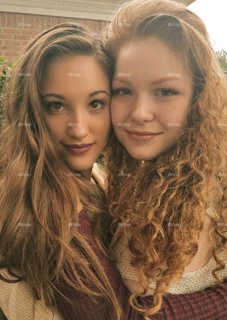 two beautiful young girls posing for a close up portrait