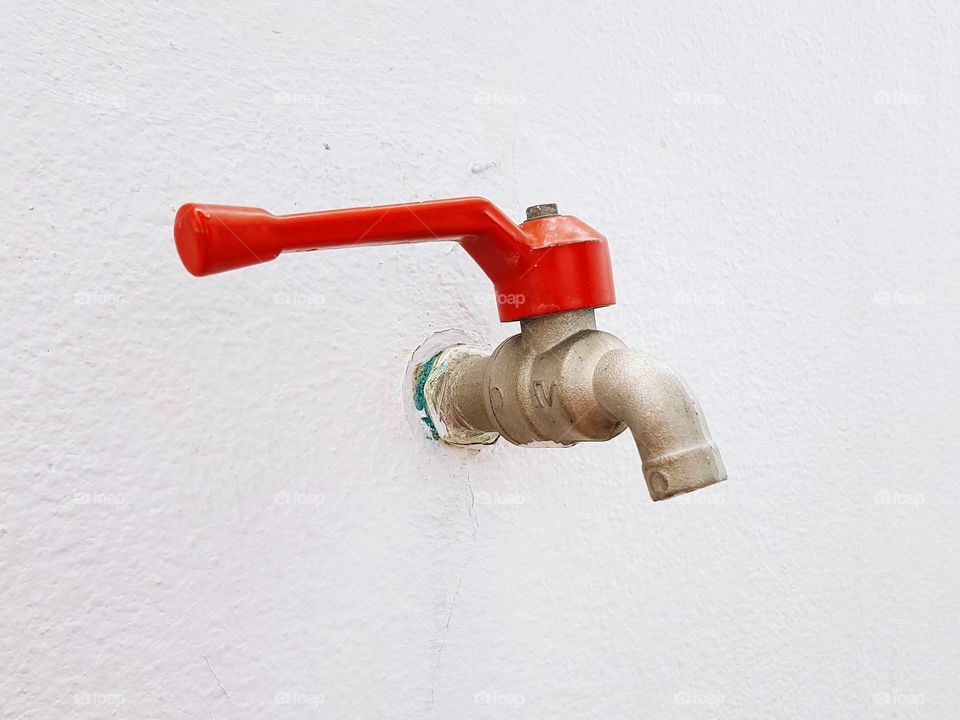 Red faucet on wall