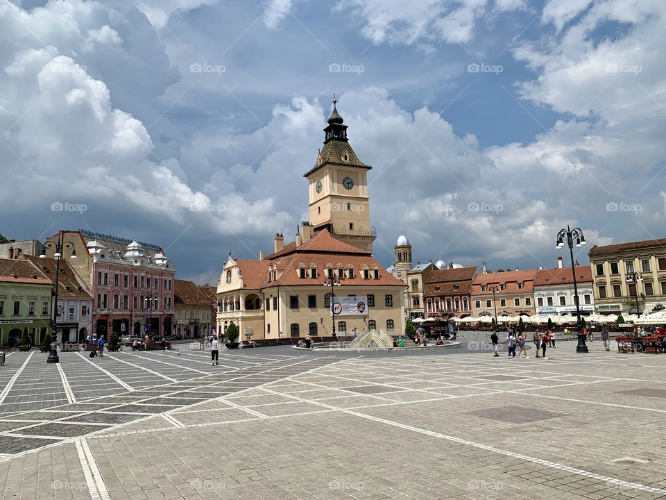 Medieval old city center square, clock tower and colorful buildings 