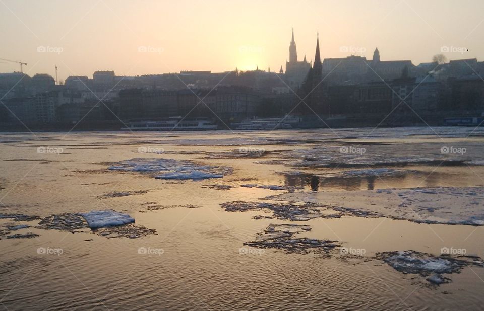 Sheets of ice drifting down the Danube as the sun sets in Budapest, Hungary.