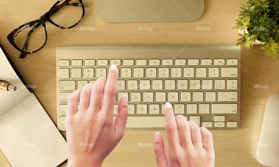 Two hands working on Apple computer