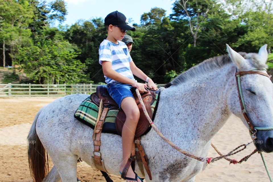 Boy learning to ride the horse