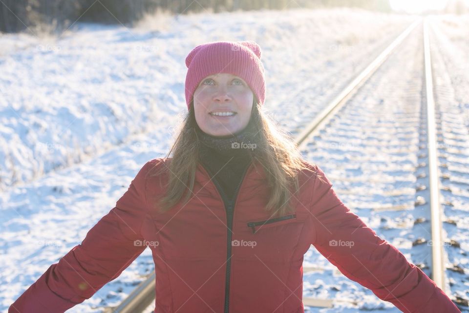 Woman with red hat smiling at sunset