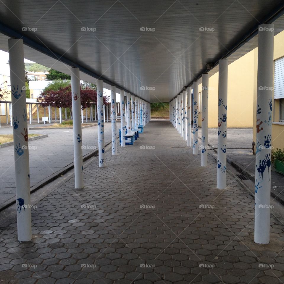 School alley with columns decorated with painted hands 
